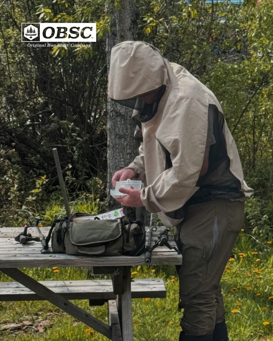 Man in Original Bug Shirt preparing fishing tackle at a picnic table